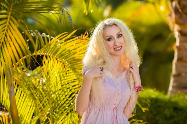在粉红色的连衣裙在花园里的金发女郎 — 图库照片