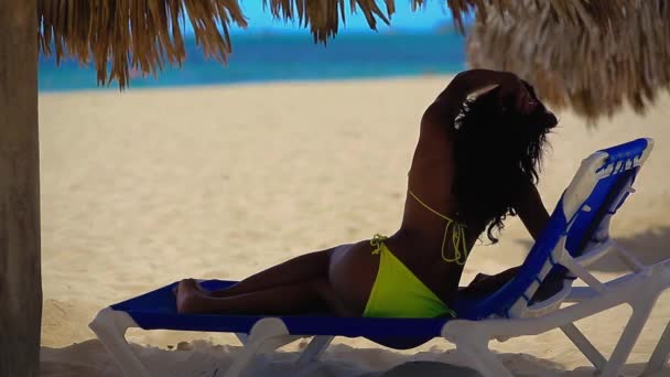 Μαύρο κορίτσι στο μπικίνι που ακουμπά στην παραλία — Αρχείο Βίντεο