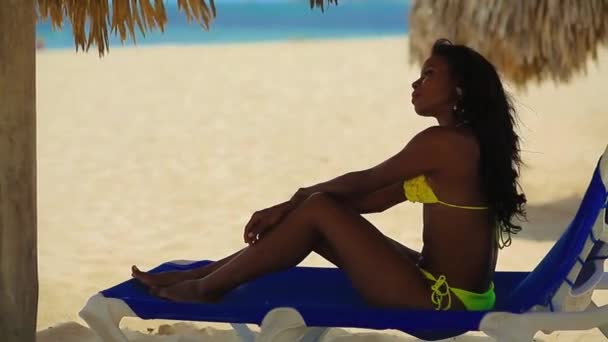 Negro chica en bikini descansando en la playa — Vídeos de Stock