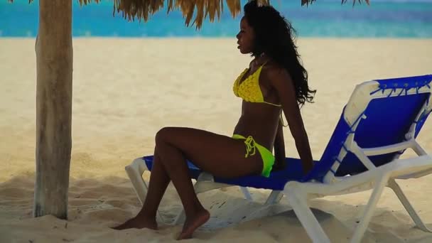 Negro chica en bikini descansando en la playa — Vídeos de Stock