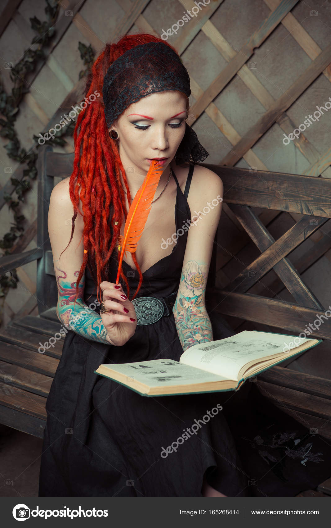 Tattooed Girl With Red Dreadlocks Sitting On A Bench