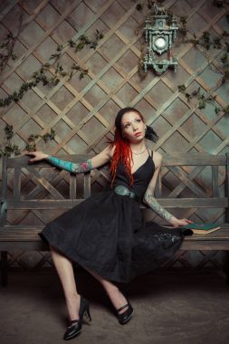 Bankta içinbeklediğini dövmeli kız kırmızı dreadlocks ile