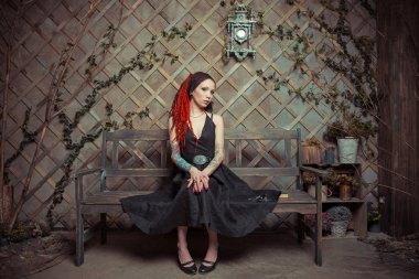 Bankta içinbeklediğini dövmeli kız kırmızı dreadlocks ile