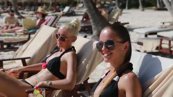 Dos chicas en bikini y gafas de sol en la playa — Vídeo de stock