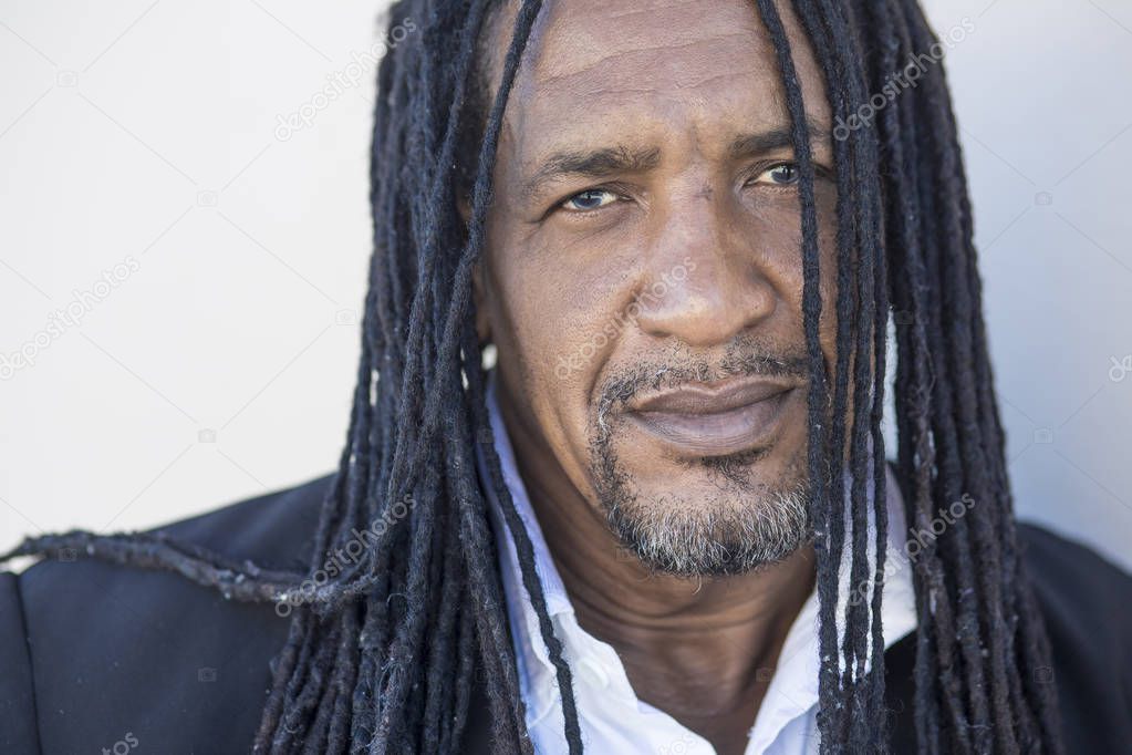 Portrait of adult strong black men with long dreadlocks and blue