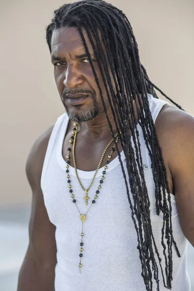 Yetişkin güçlü siyah adamla uzun dreadlocks ve mavi portresi