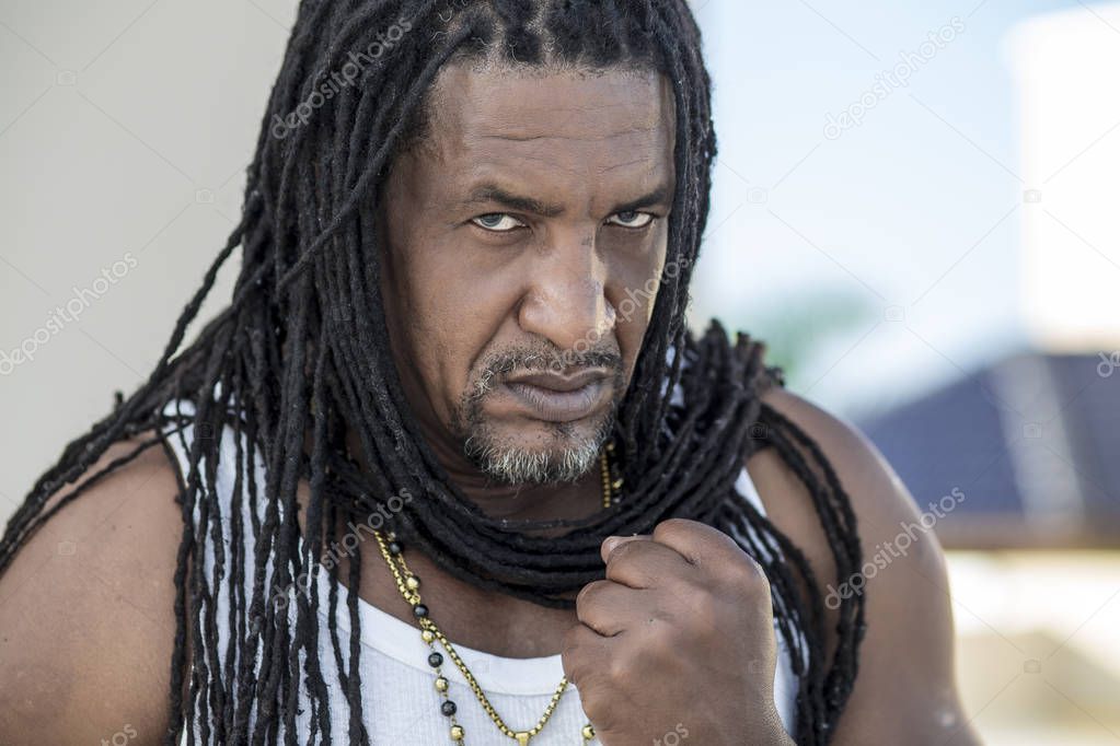 Portrait of adult strong black men with long dreadlocks and blue