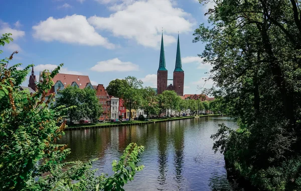 Luebeck, yeşil çerçeveli nehir manzaralı şehir manzarası.