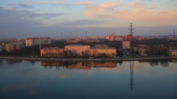 A direct top view of Saint-Petersburg and Neva river in early spring in the rays of the dawn sun. Traffic on the embankment, reflection of buildings in the water — 비디오