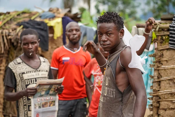 Diciembre de 2019. África, Uganda, escenas de la vida africana, hombres de una tribu de pigmeos con regalos de turistas - alas blancas, dulces, periódico — Foto de Stock