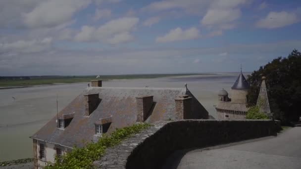 Julay, 2019, France, Mont Saint-Michel είναι μια πόλη-φρούριο νησί στην ακτή. Περπατήστε μέσα από το φρούριο, θέα στους πυργίσκους και τα κεραμίδια και τη γύρω περιοχή και τα ιπτάμενα πουλιά — Αρχείο Βίντεο