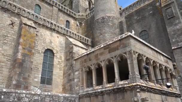 Julay, 2019, Francia, Mont Saint-Michel è una città isola-fortezza sulla costa. Movimento della macchina fotografica sulle pareti in muratura dell'Abbazia gotica, cielo blu — Video Stock