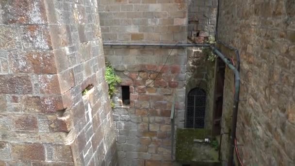 Julay, 2019, France, Le Mont Saint-Michel est une ville forteresse située sur la côte. Mouvement de la caméra sur les murs de maçonnerie de l'abbaye gothique vers le haut, ciel bleu 