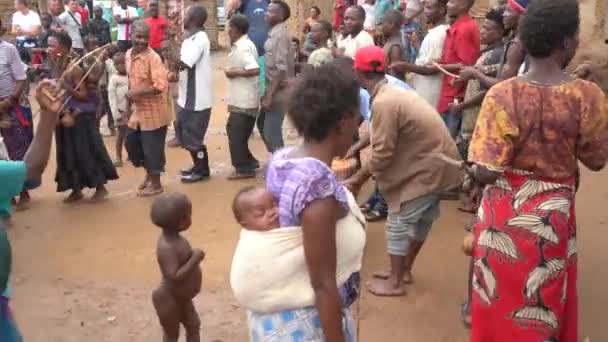 Diciembre de 2019. África, Uganda, una tribu de pigmeos, la gente baila en un círculo, mujeres con niños, un hombre toca la batería — Vídeo de stock