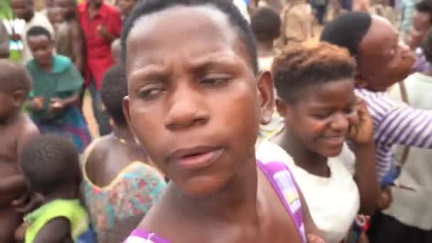 Грудень 2019. Африка, Уганда, плем'я пігмеїв, люди танцюють, обличчя жінки з дитиною близько. — стокове відео
