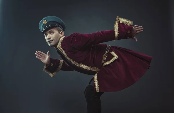 A man portraying a glamorous character in a maroon suede tailcoat and cap Royalty Free Stock Photos