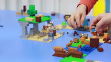 İki çocuk inşaatçıyla oynar, bir şehir inşa eder.