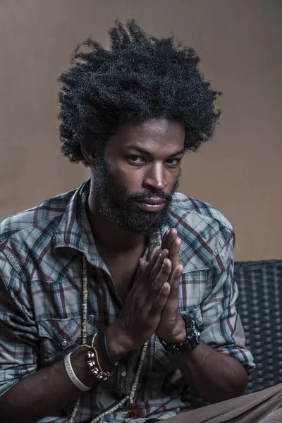 Retrato de um afro- dominicano em uma camisa quadriculada dobrou as mãos, algo em mente — Fotografia de Stock