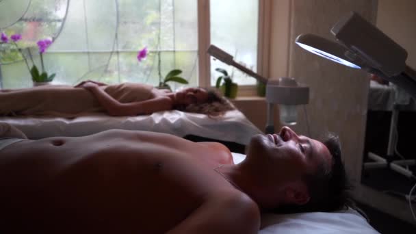 Muž leží se zavřenýma očima na masážním stole — Stock video