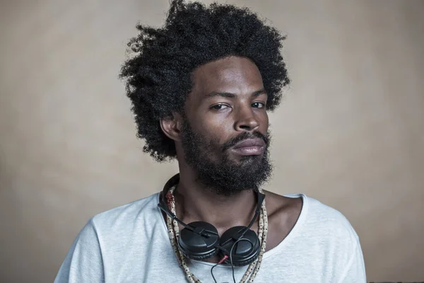 Retrato de un afroamericano de pelo rizado con auriculares alrededor de su cuello — Foto de Stock