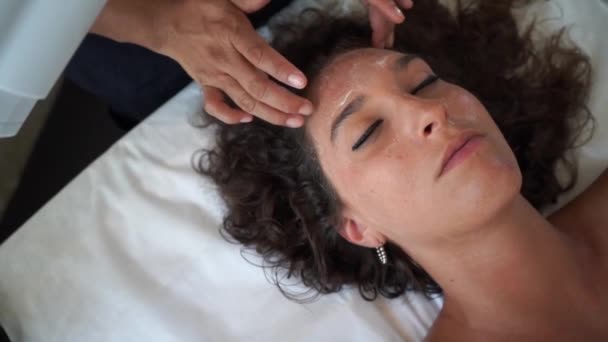 Masáž obličeje s krémovým drhnutí pro mladou ženu — Stock video