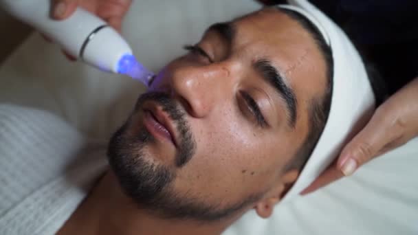 Аппаратно-косметологическая процедура очистки пор кожи для молодого человека — стоковое видео