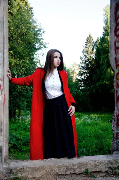 Schönes Mädchen in einem roten Mantel — Stockfoto