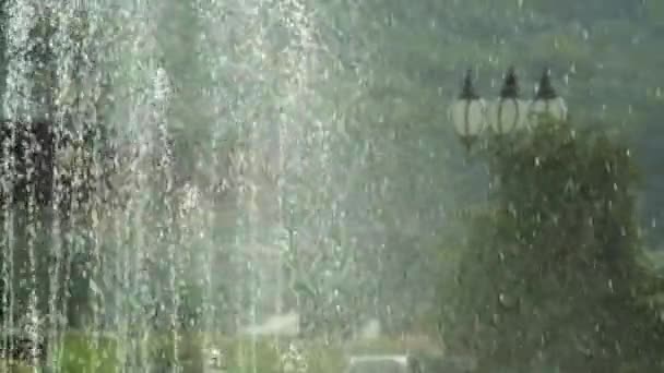 Den Springbrunnen im Park besprühen. Blendung und Bokeh von der Gischt — Stockvideo