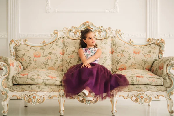 Menina bonita em um vestido roxo e blusa de flor posando para um fotógrafo. Fotosessão para a revista . — Fotografia de Stock