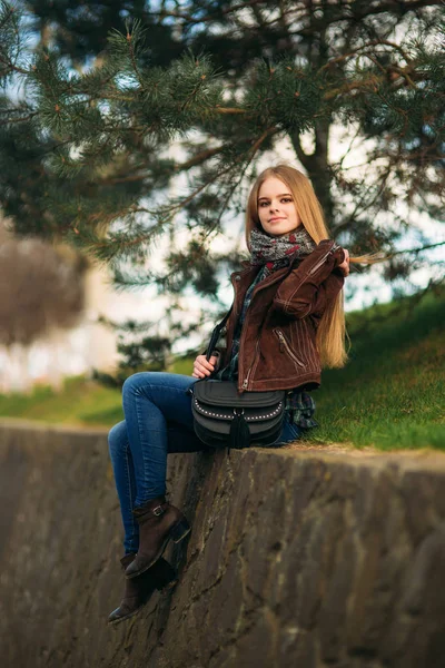 Красива дівчина йде вздовж набережної. Блондинка і коричневий піджак. Весна . — стокове фото