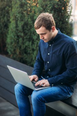 Bir kafede dizüstü bilgisayarda çalışan genç bir programcı