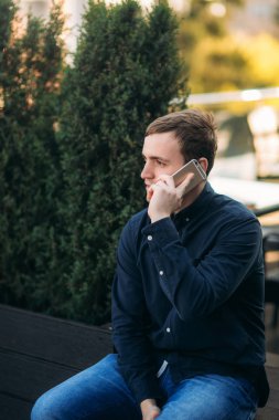 Genç bir adamın cep telefonundan konuşuyor. İş