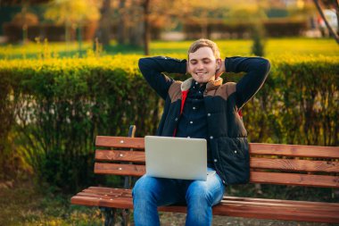 Parkta bir dizüstü bilgisayar üzerinde çalışan genç Yöneticisi. Öğle yemeği molası.