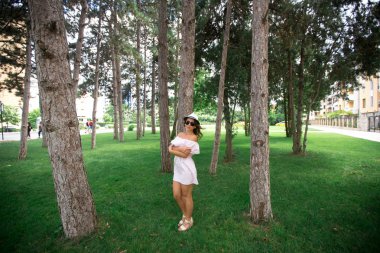 Güzel kız parkta. Yeşil çim ve güneşli hava