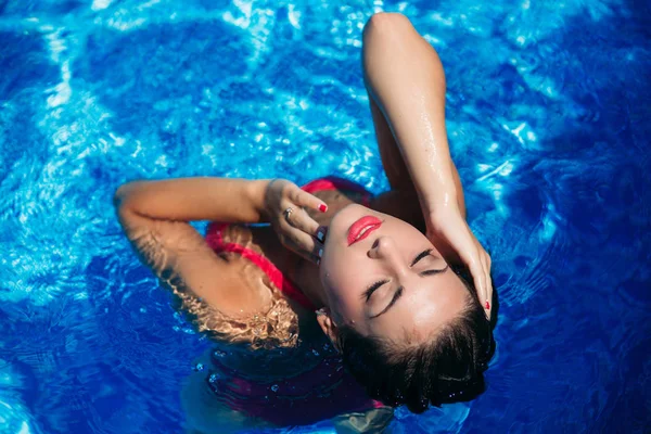 Μια νεαρή κοπέλα είναι το κολύμπι στην πισίνα κοντά στην παραλία, ηλιόλουστο καιρό. Το καλοκαίρι — Φωτογραφία Αρχείου