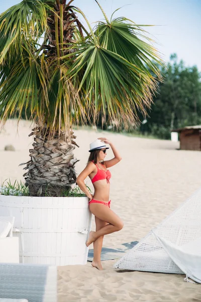 Menina sexy em um maiô rosa na praia. Verão. Tempo ensolarado . — Fotografia de Stock