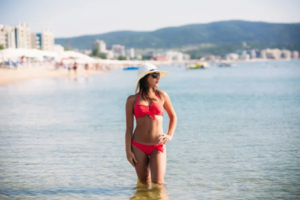 Sexy dziewczyna w różowy strój kąpielowy na plaży. Letnich. Słoneczna pogoda. — Zdjęcie stockowe