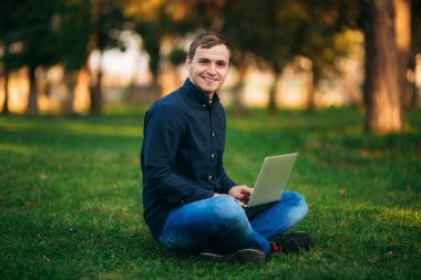 Parkta bir dizüstü bilgisayar üzerinde çalışan genç Yöneticisi. Öğle yemeği molası.