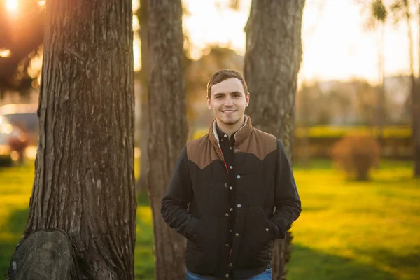 Un ragazzo in un parco con una camicia blu scuro. Primavera . — Foto Stock