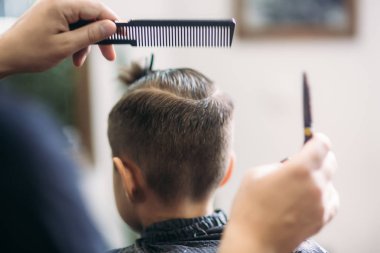 Küçük çocuk saç kesimi tarafından Kuaför Berber Dükkanı, sandalyede otururken Başlarken.