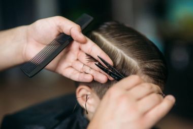 Küçük çocuk saç kesimi tarafından Kuaför Berber Dükkanı, sandalyede otururken Başlarken.