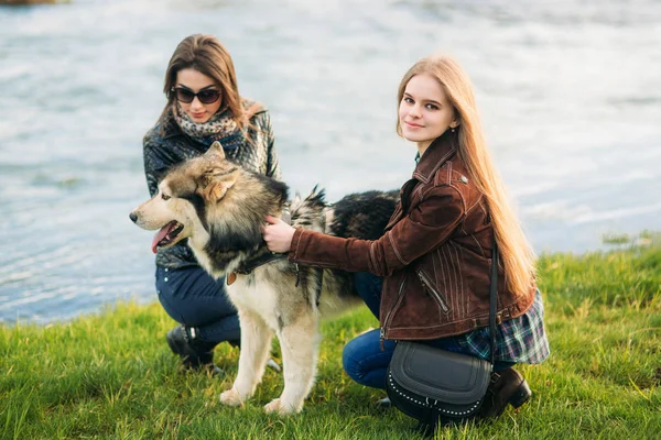 Ein schönes Mädchen läuft die Böschung entlang. blonde Haare und braune Jacke. Frühling. — Stockfoto