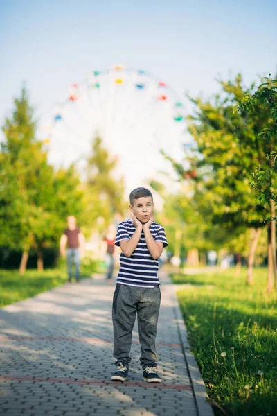 Mały chłopiec w t-shirt w paski patrzy przez lornetkę. Wiosna, słoneczna pogoda. — Zdjęcie stockowe