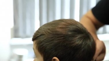 Küçük çocuk saç kesimi tarafından Kuaför Berber Dükkanı, sandalyede otururken Başlarken.