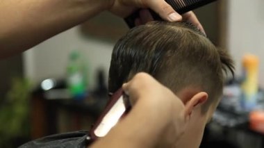 Küçük çocuk saç kesimi tarafından Kuaför Berber Dükkanı, sandalyede otururken Başlarken.