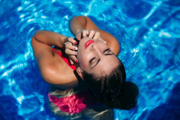 Μια νεαρή κοπέλα είναι το κολύμπι στην πισίνα κοντά στην παραλία, ηλιόλουστο καιρό. Το καλοκαίρι — Φωτογραφία Αρχείου