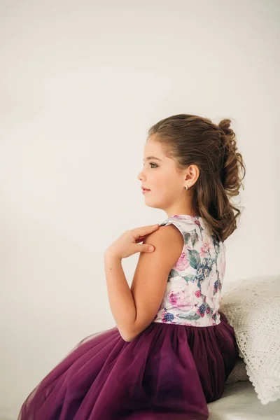 Menina bonita em um vestido roxo e blusa de flor posando para um fotógrafo . — Fotografia de Stock