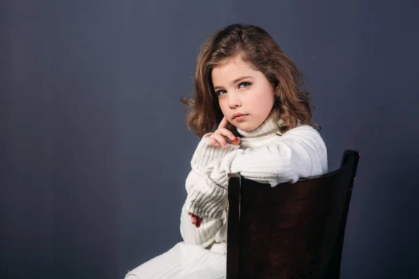 Petite belle fille aux cheveux bruns dans un pull léger et avec une jupe de tulle. Une princesse pose pour un photographe . — Photo