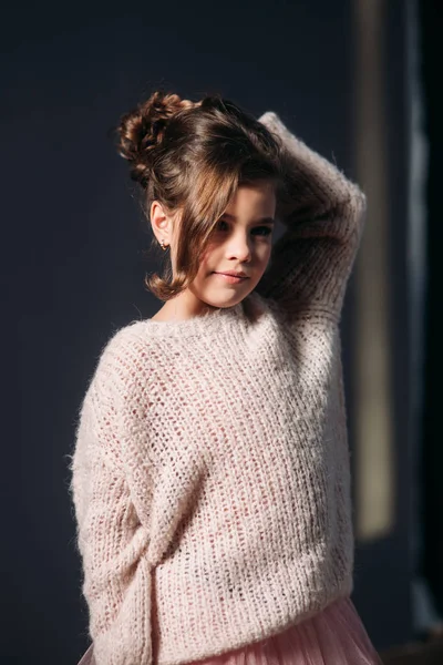 Niña hermosa con el pelo castaño en un suéter ligero y con una falda de tul. Una princesa posa para un fotógrafo . — Foto de Stock