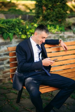 Damat Düğün günde bir koyu takım elbiseli, güneşli bir gün.